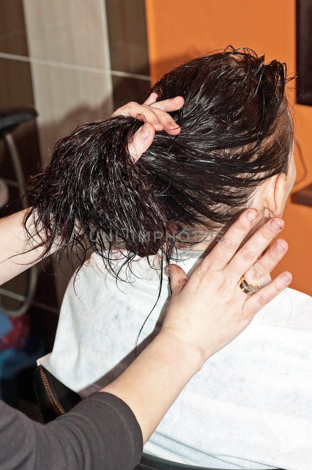 Stylist work on woman hair in salon