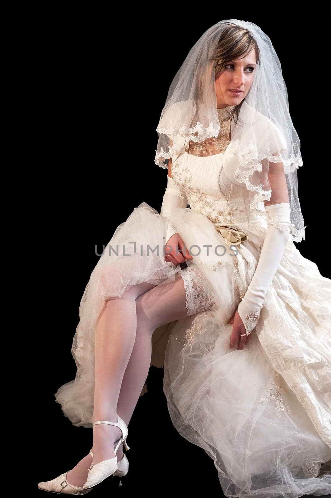 Young beautiful bride in a white wedding dress on the black background