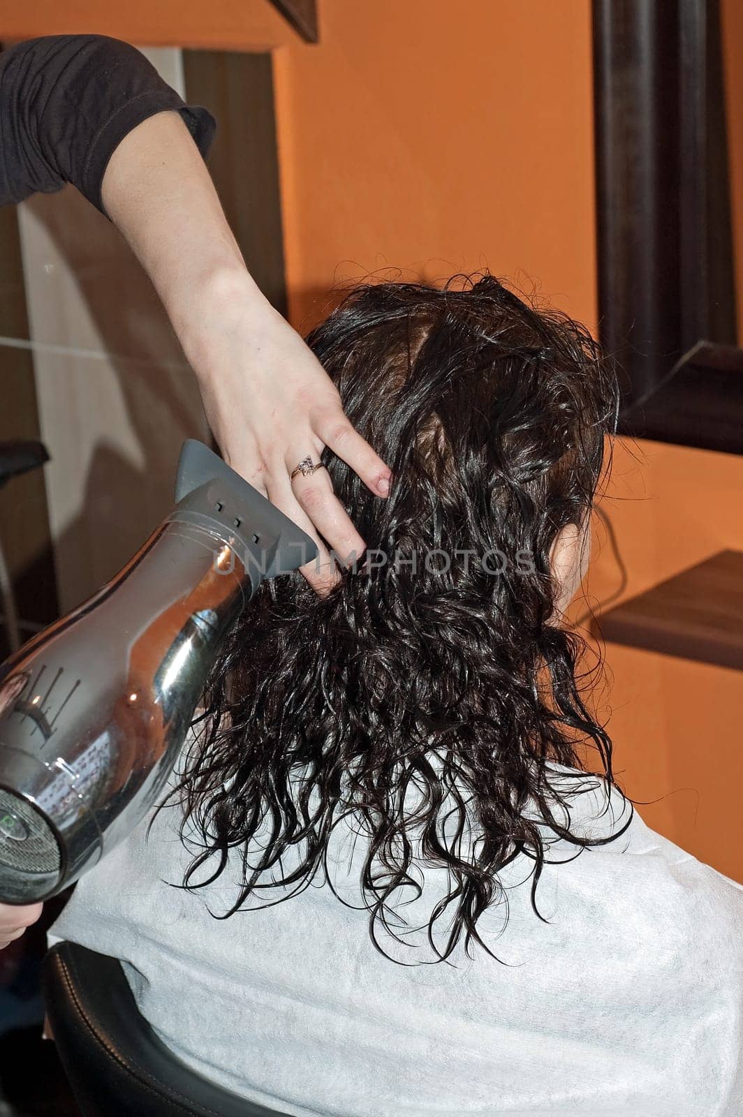 Stylist work on woman hair in salon