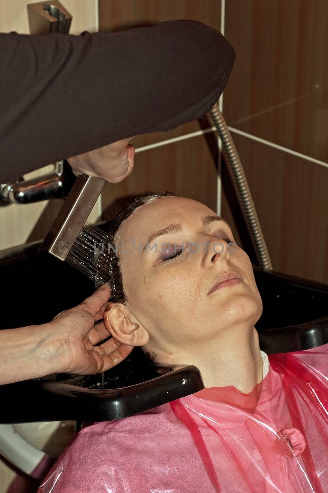 Stylist work on woman hair in salon