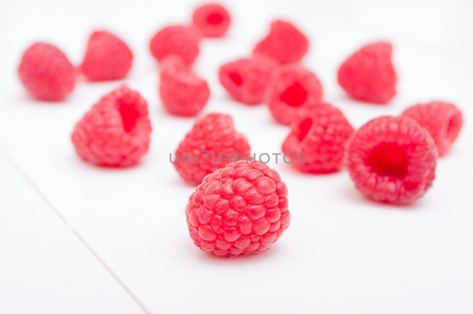 Fresh Ripe Raspberries on White Wooden Table
