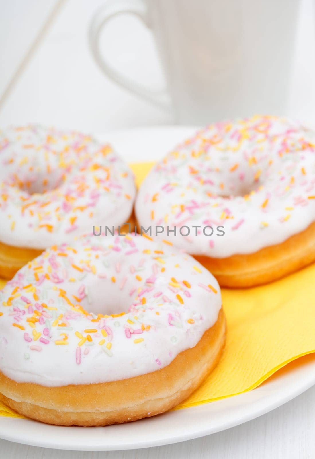 Donuts With Colorful Sprinkles, Plates and Mugs on Table - Shallow Depth Of Field