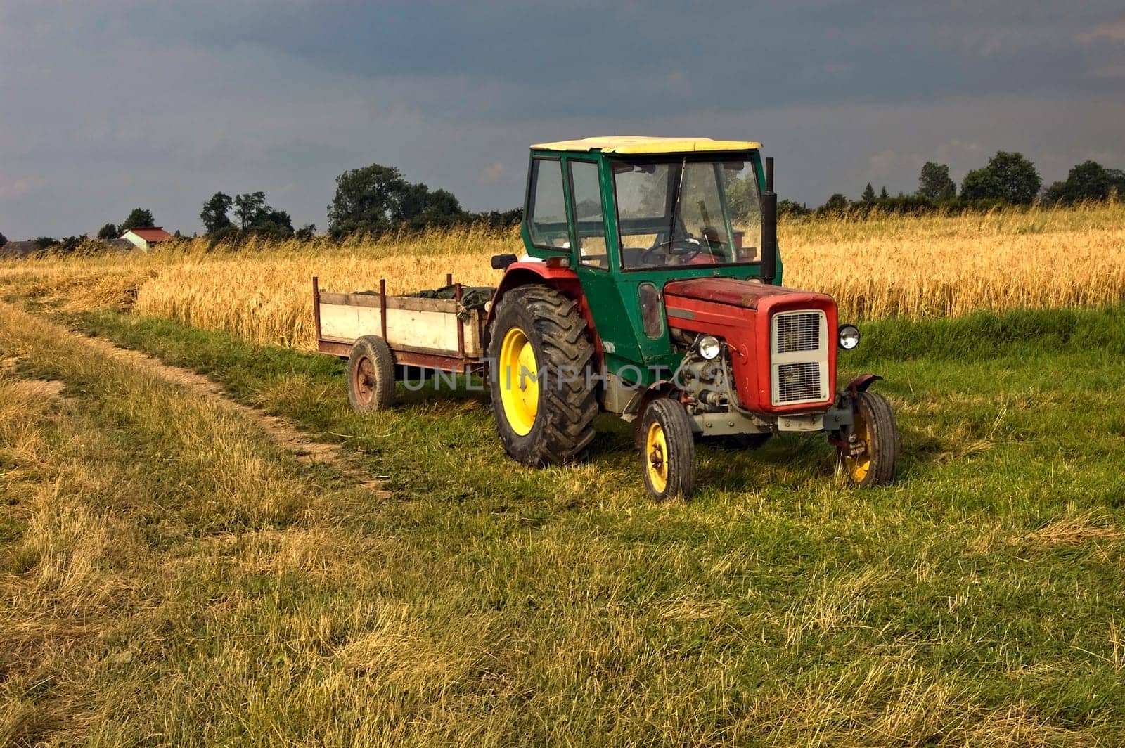 An old farm tractor on the side of an agriculture field in South Poland