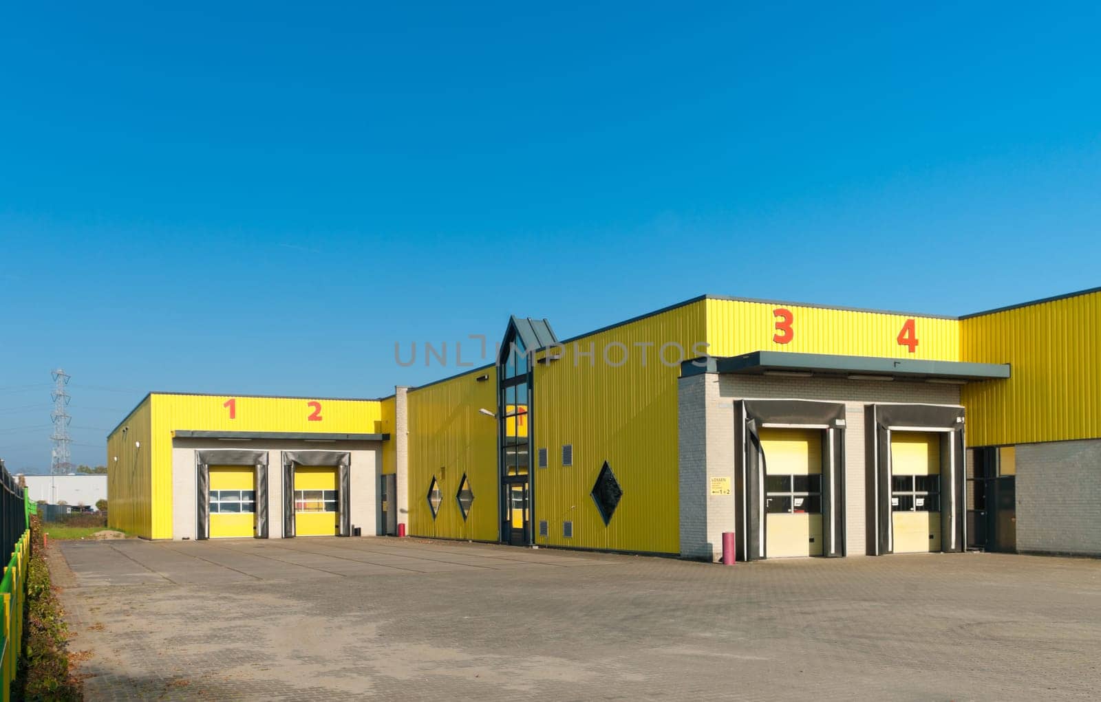 yellow industrial warehouse with numbered loading docks