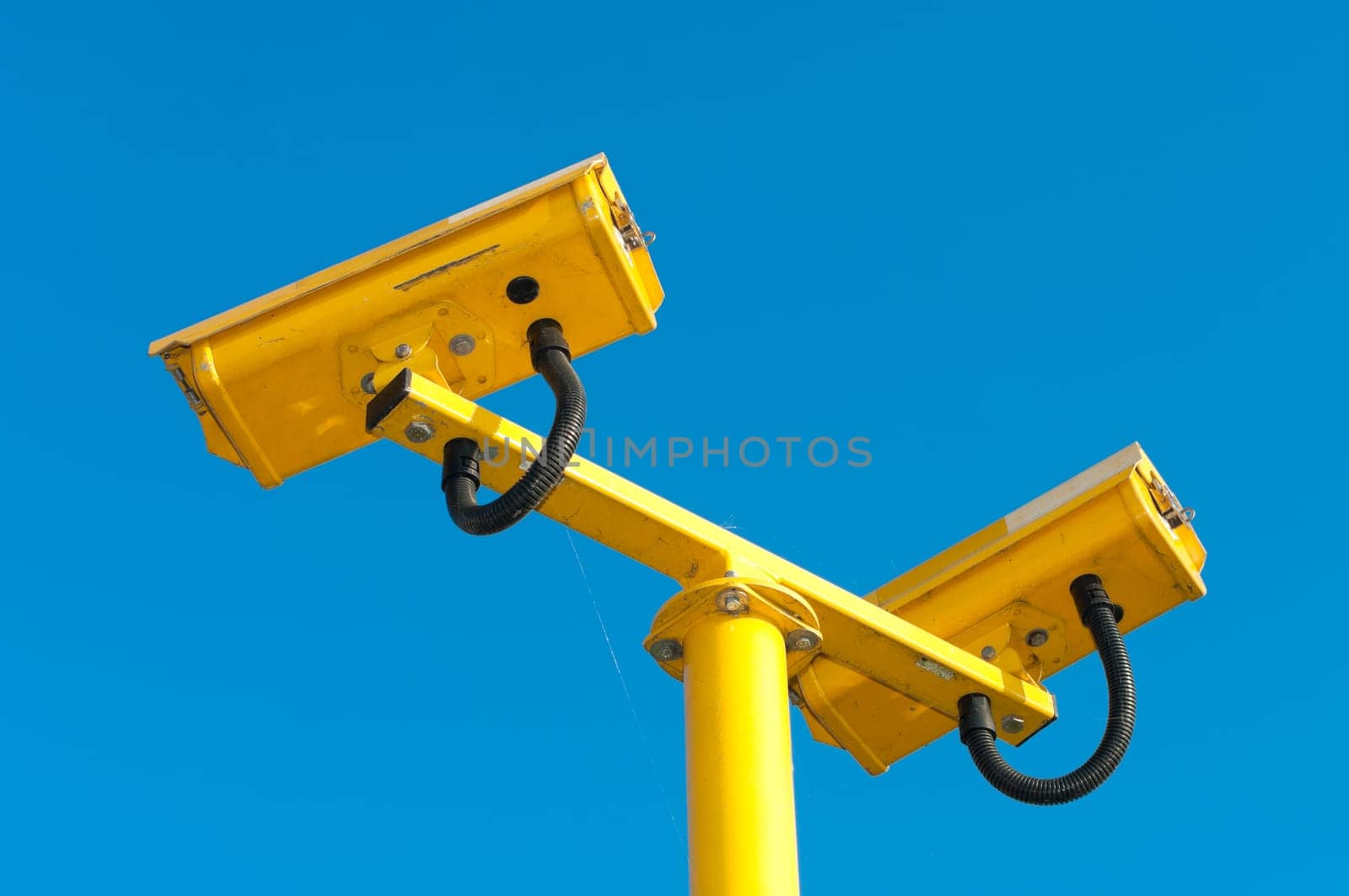 double surveillance security camera or CCTV against blue sky