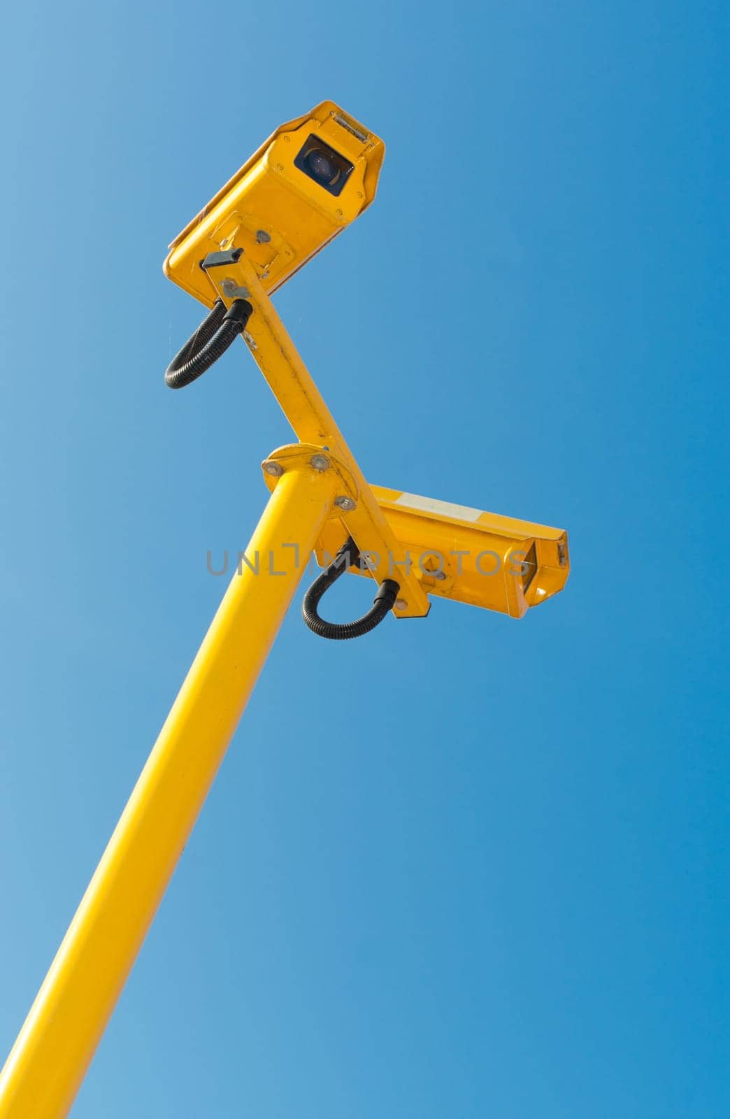 double surveillance security camera or CCTV against blue sky