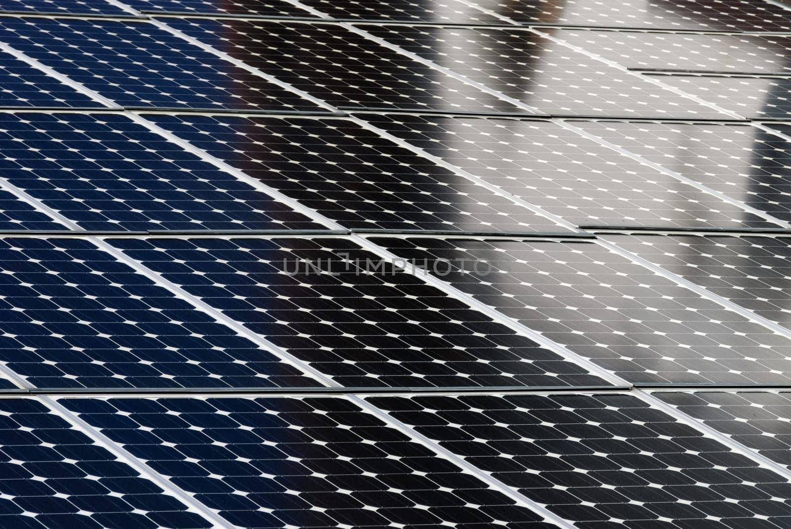 solar panels side by side with the reflection of a building