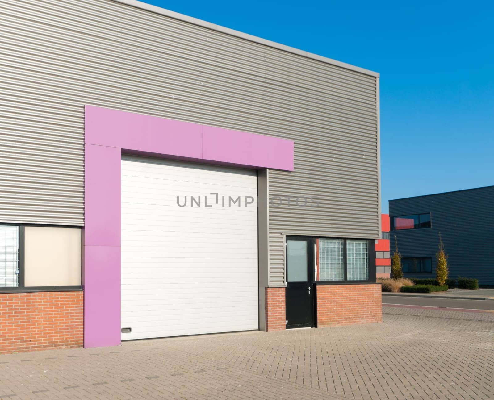 industrial warehouse with roller door with pink accent