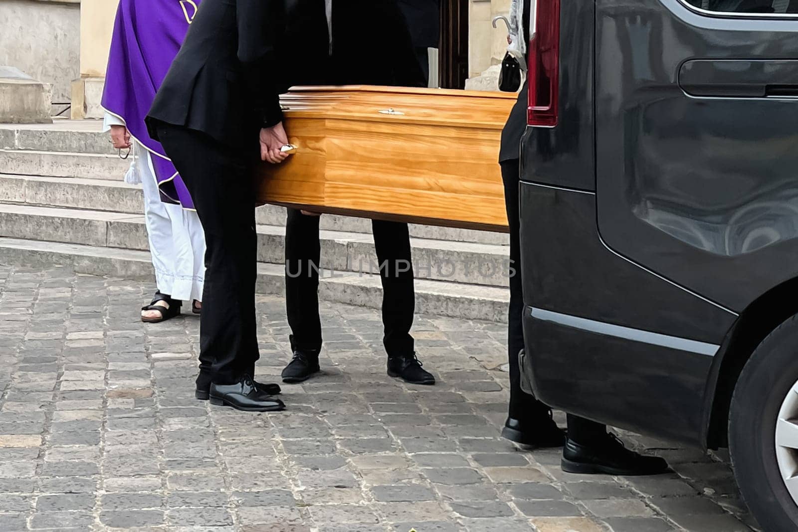 Funeral service loading the coffin into the hearse