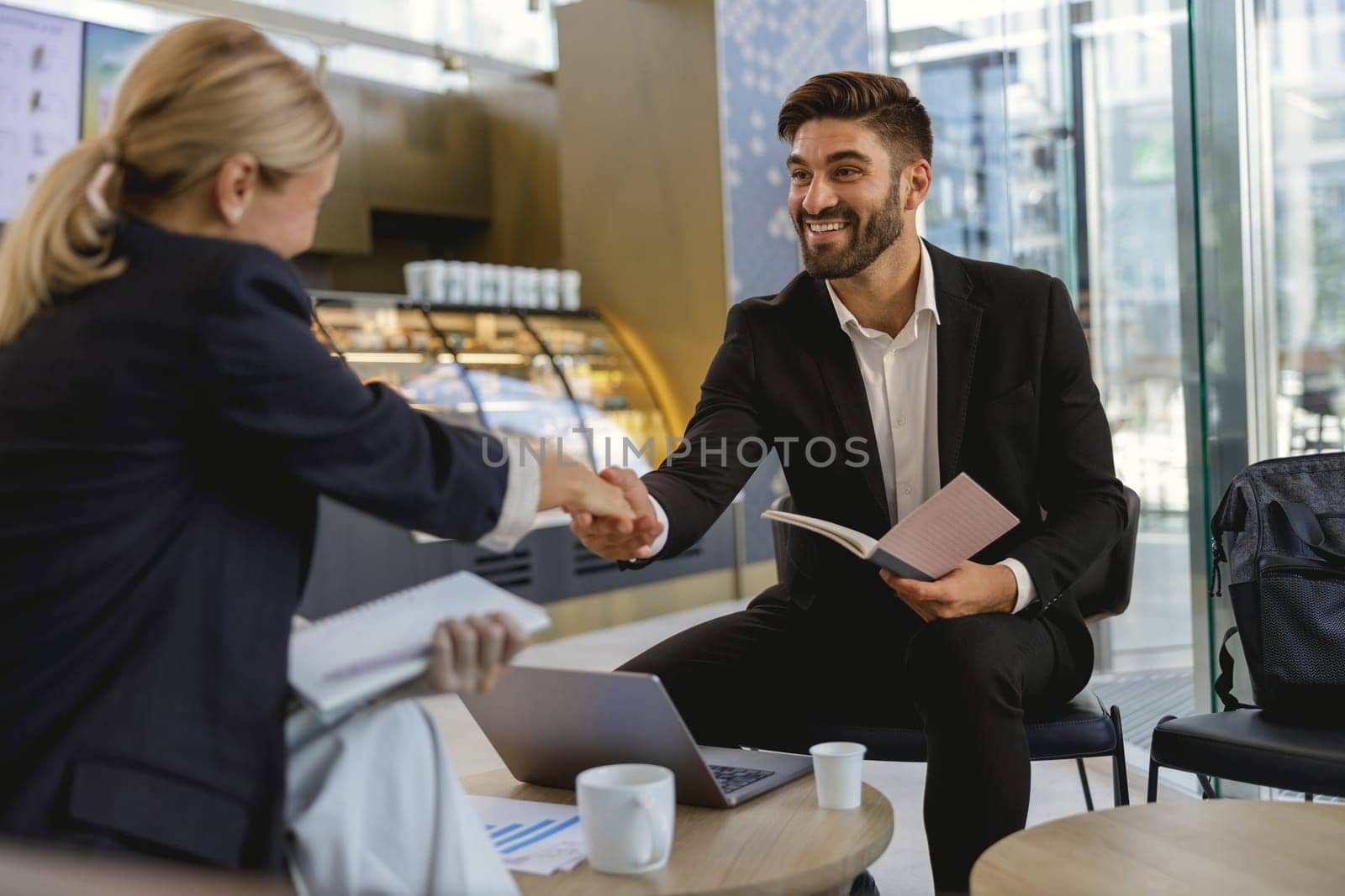 Business people shaking hands after agreement in front of the cozy cafe background