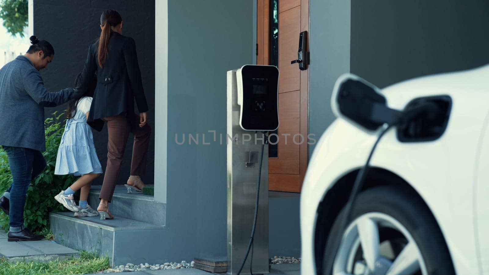 Concept of progressive family with home charging station for electric vehicle. by biancoblue