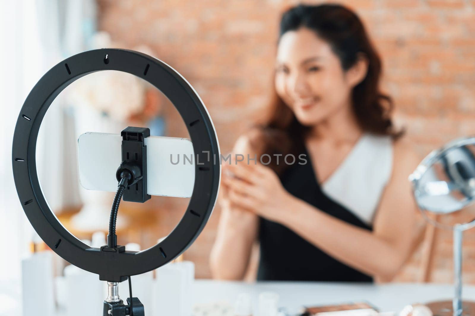 Woman influencer shoot live streaming vlog video review makeup uttermost social media or blog. Happy young girl with cosmetics studio lighting for marketing recording session broadcasting online.