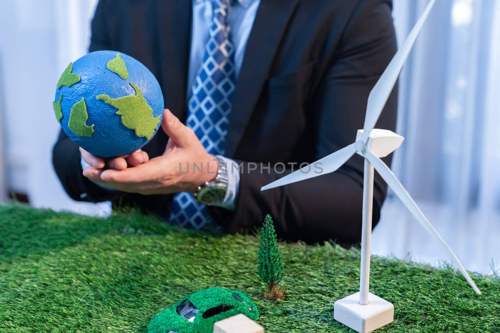 Eco business and save Earth concept shown by businessman or CEO holding paper globe in office with eco friendly mockup to promote CO2 and carbon footprint reduction for greener future. Quaint