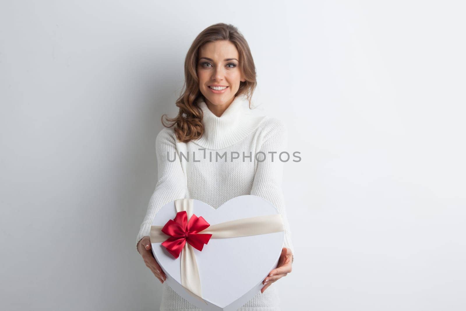 Beautiful woman holding heart shaped gift box