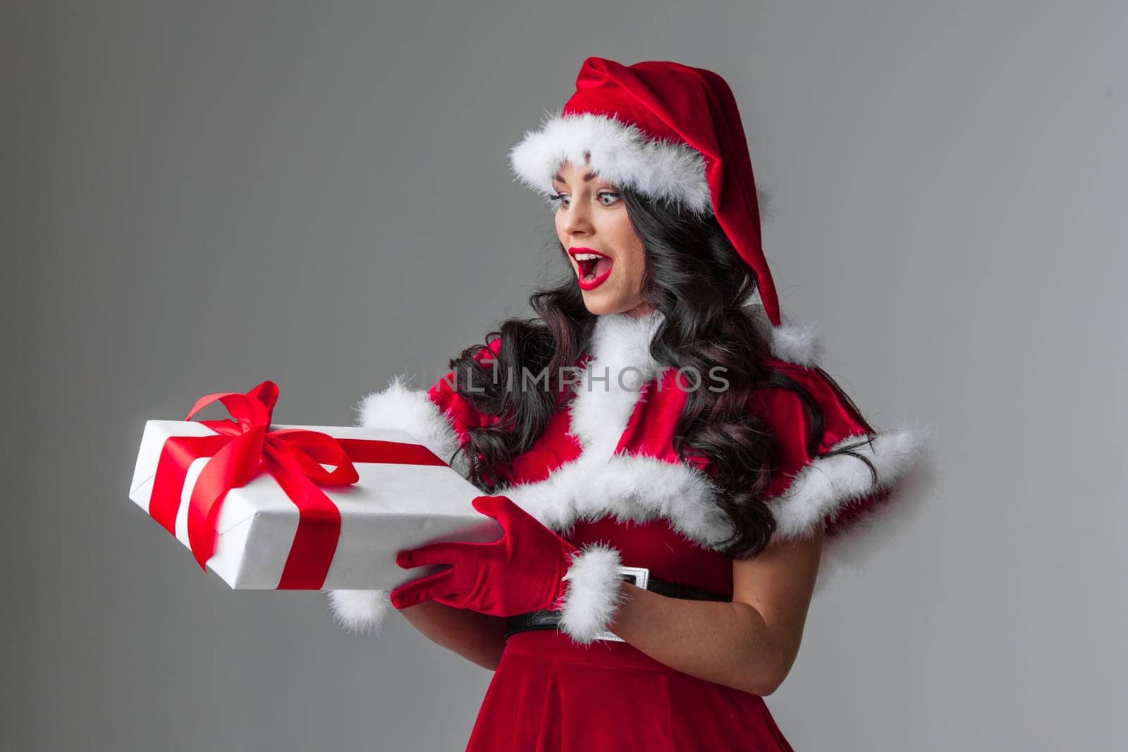 Beautiful woman in Santa Claus style dress with gift box