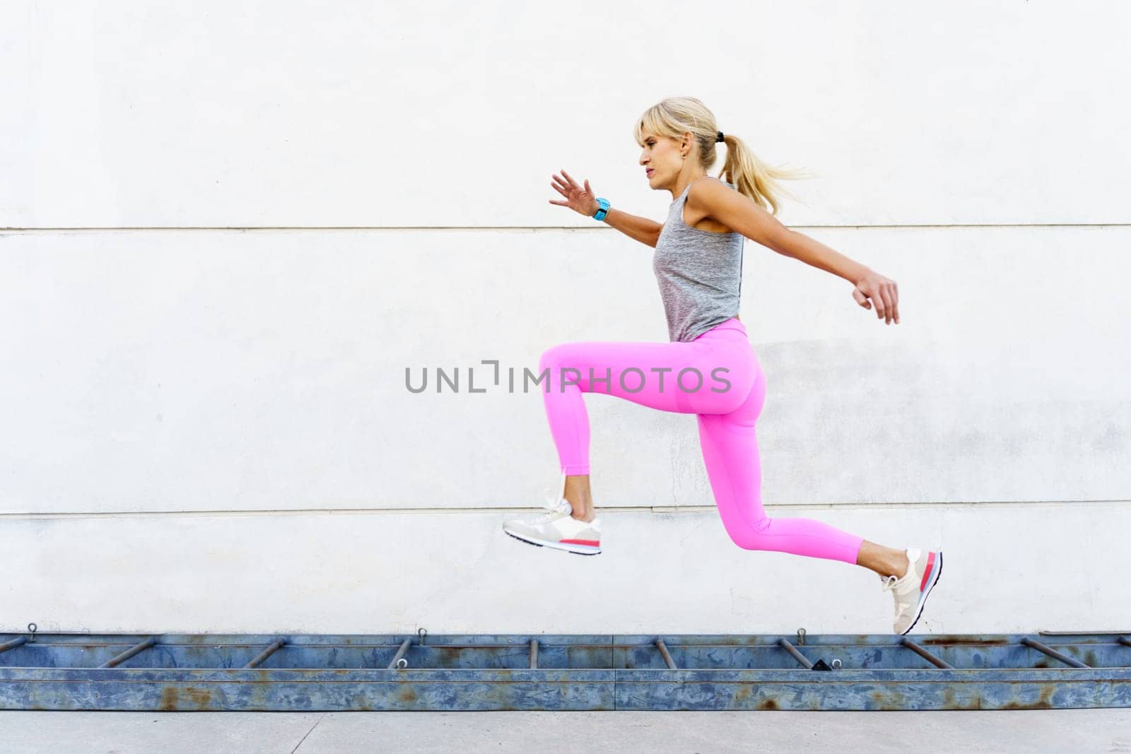 Woman in sportswear running on street in daylight by javiindy