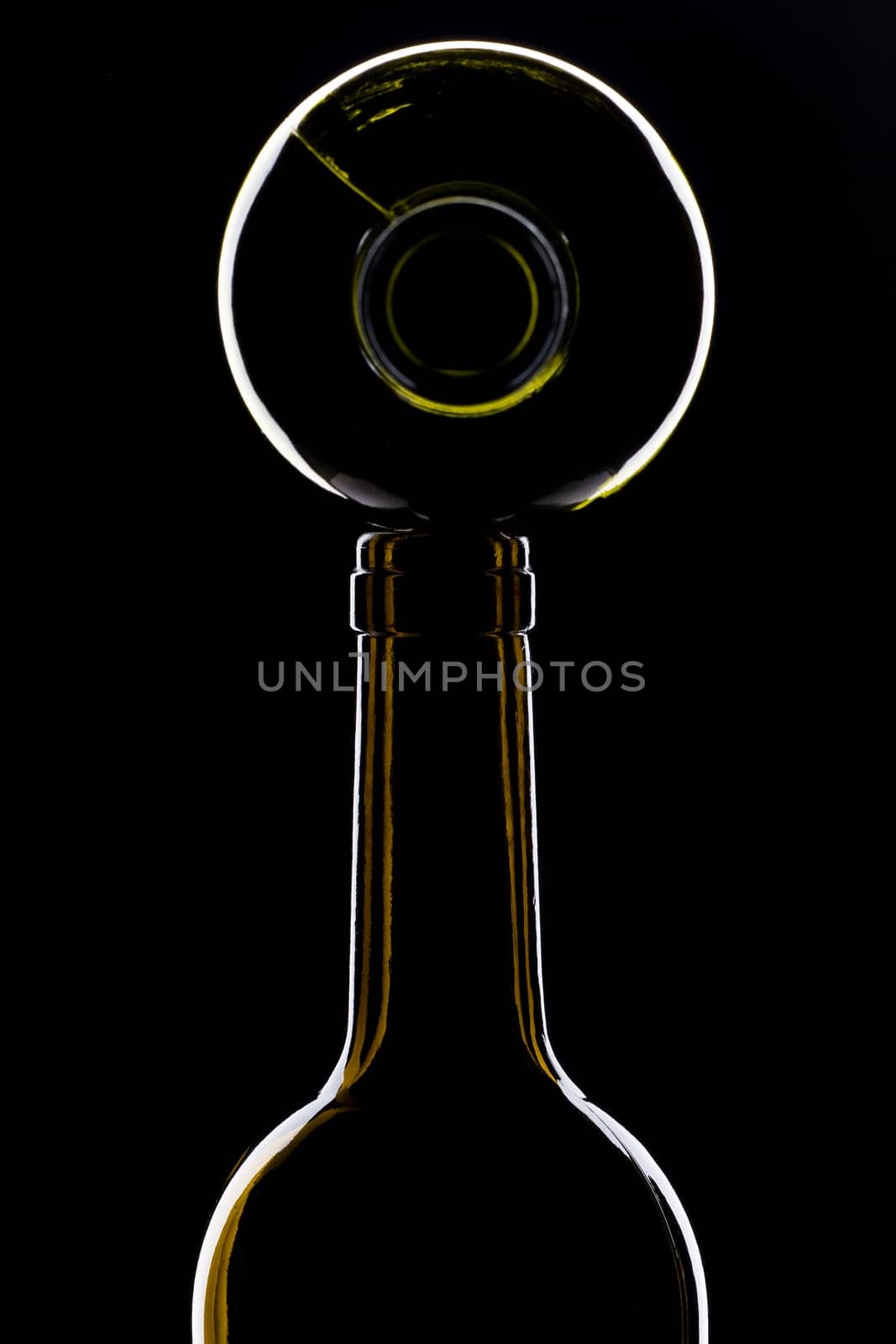 green wine bottles shiny on top of each other against black background
