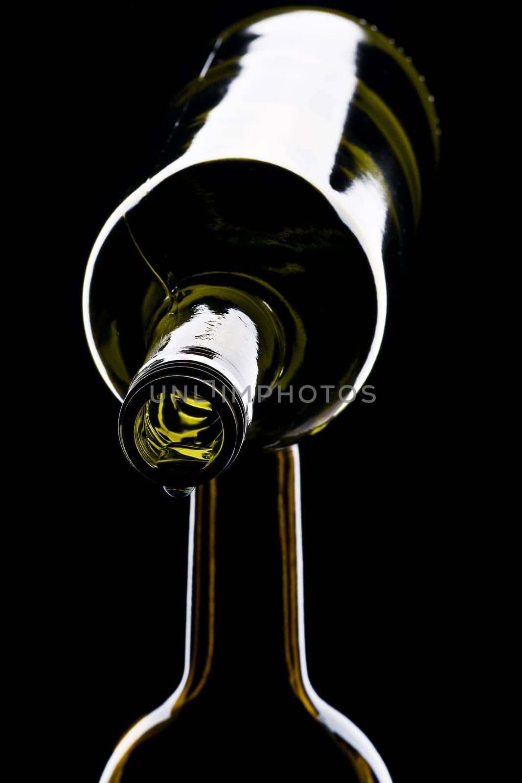 green wine bottles shiny against black background with drops