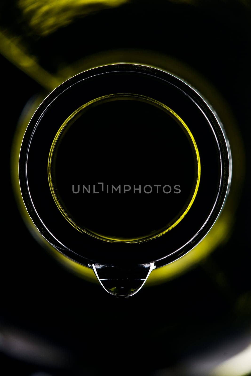 green wine bottle with drops shiny against black background