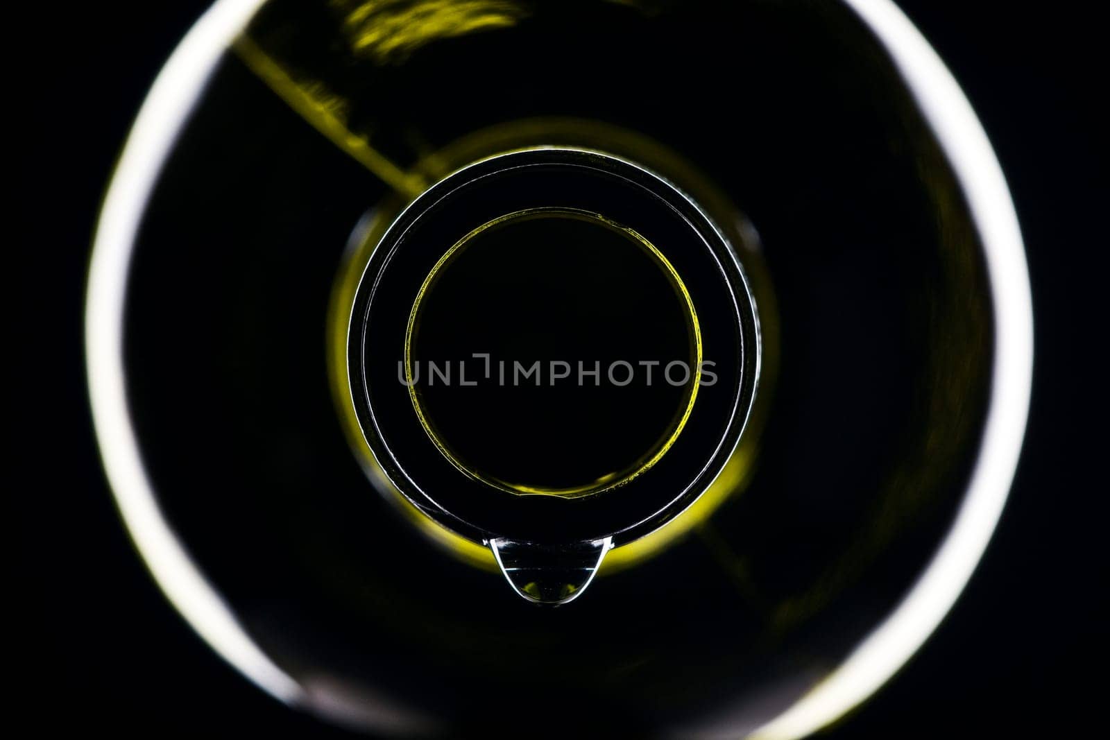 green wine bottle with drops shiny against black background