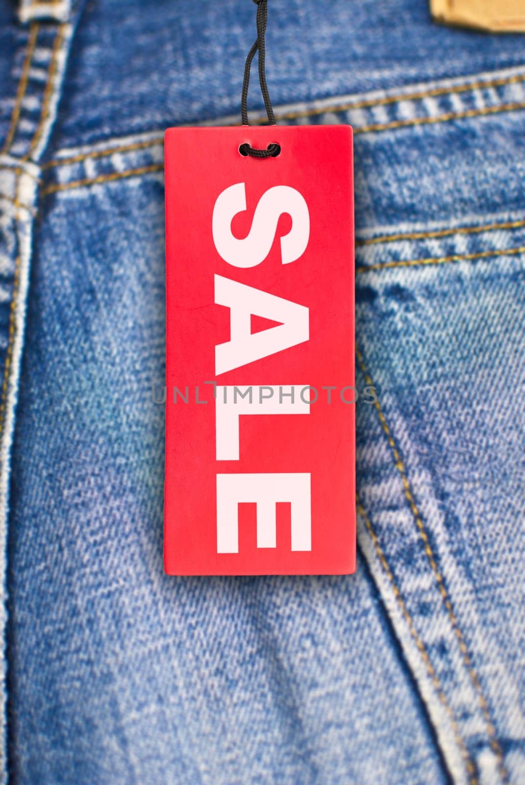 Red Sale Sign With Jeans in Background
