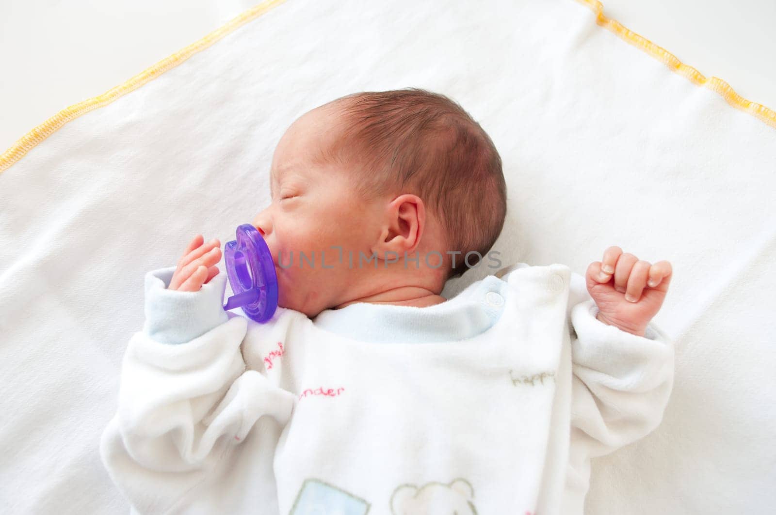 newborn premature baby boy held quiet with a pacifier