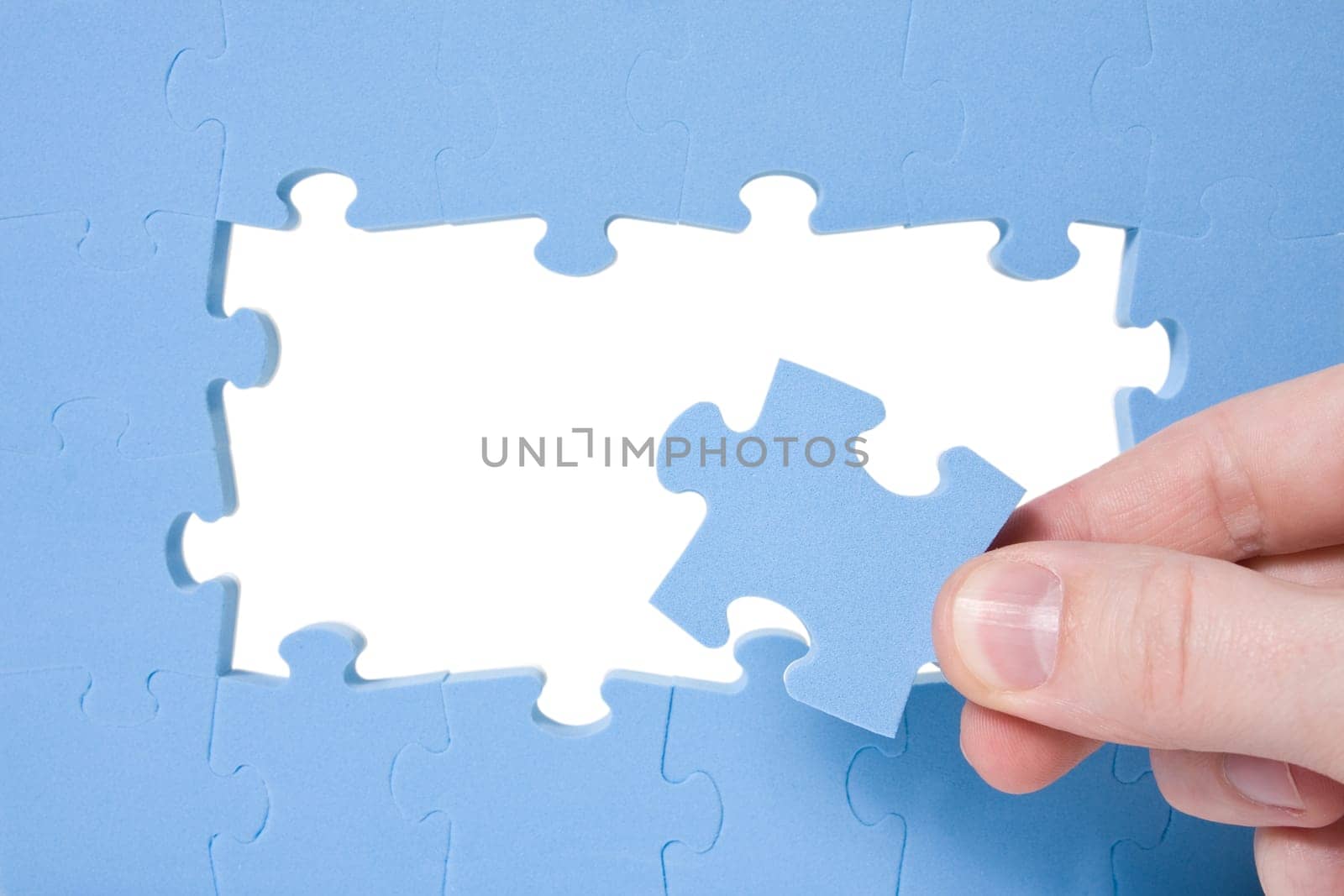 Hand collecting a part of a blue puzzle