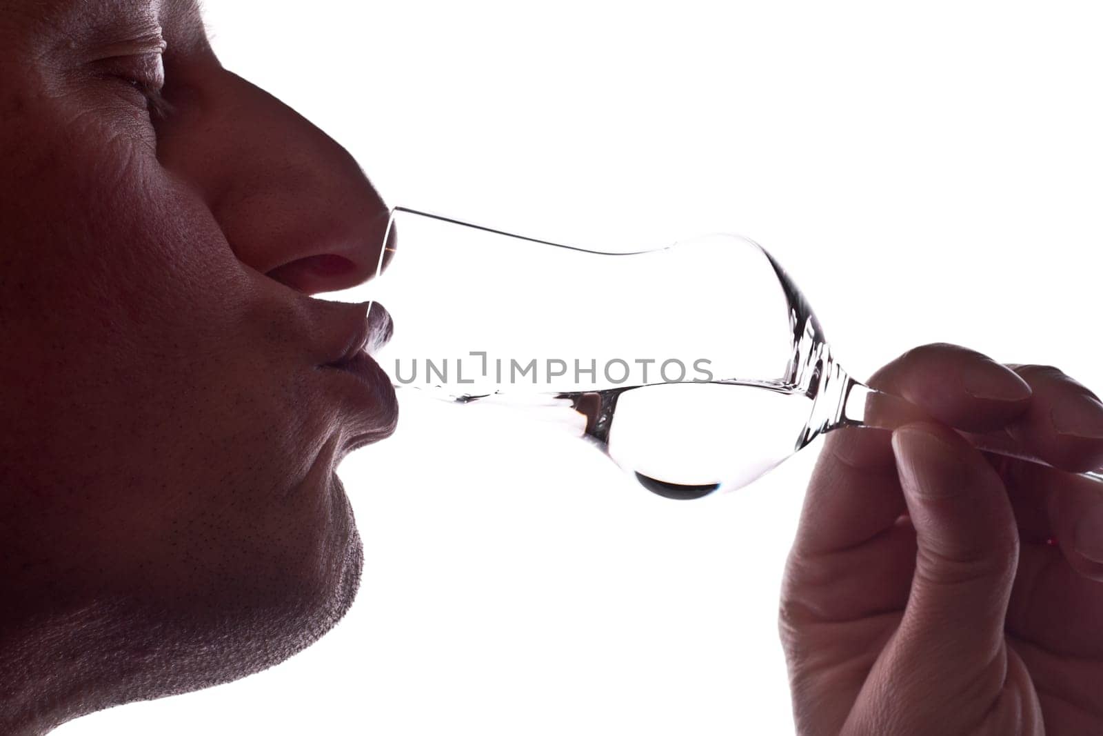 Man drinking a grappa from a grappa glass