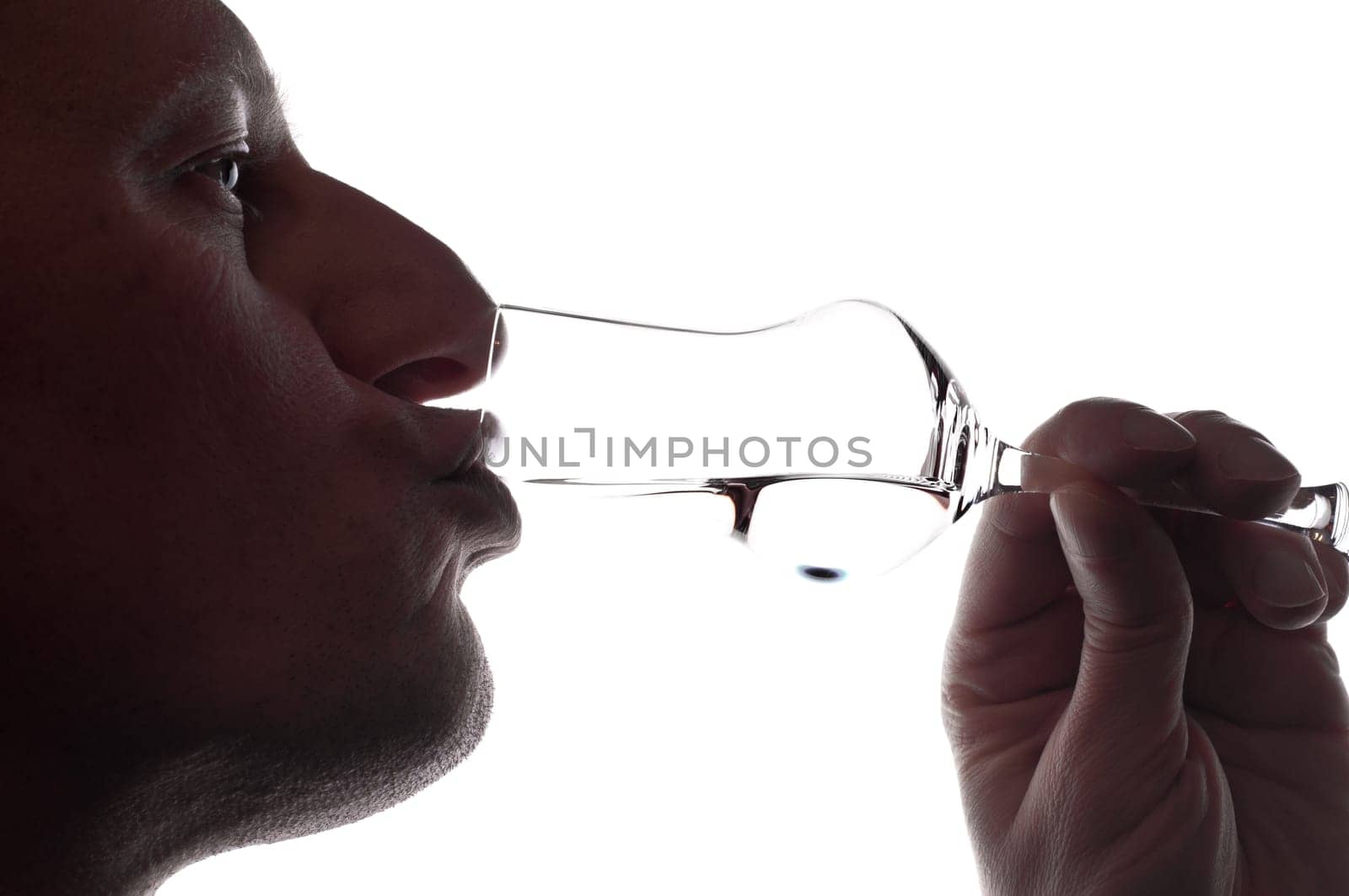 A man drinks a grappa from a grappa glass