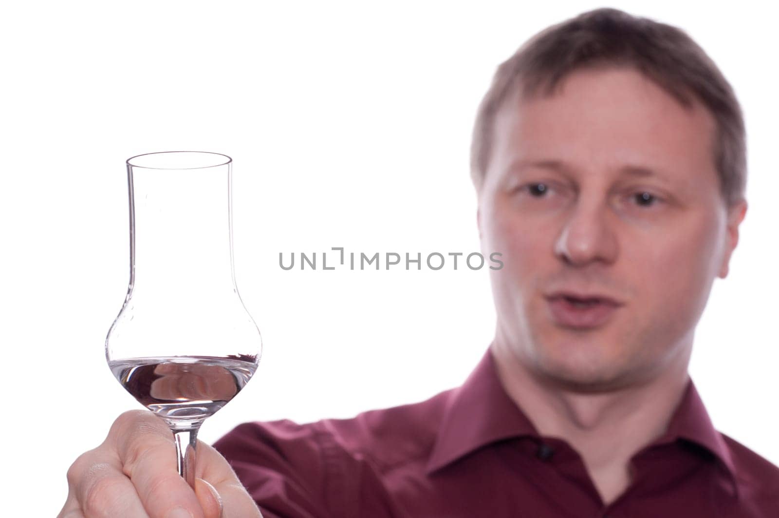 A drunk man raises his glass of liquor