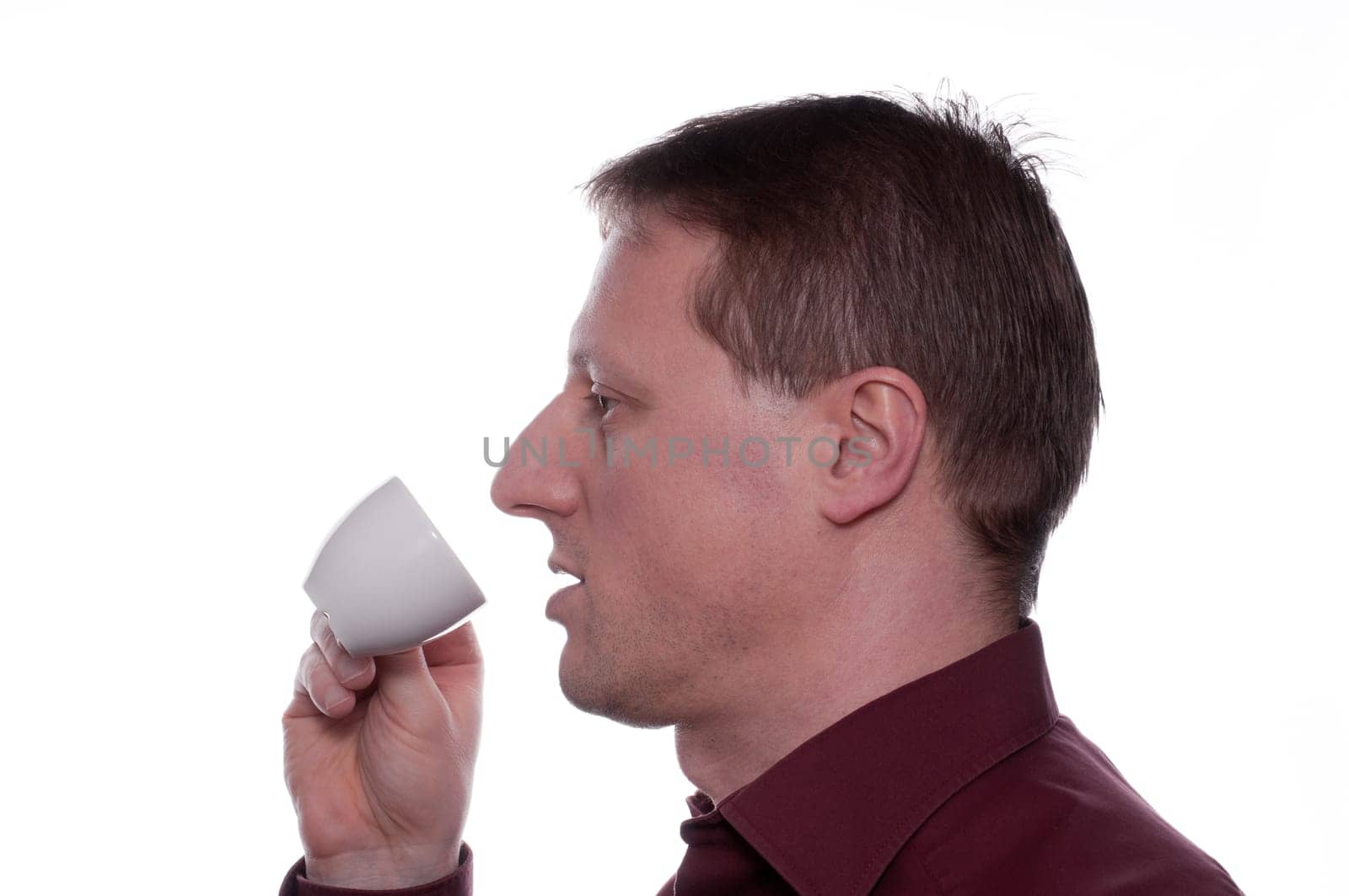 A man drinks an espresso coffee from a cup