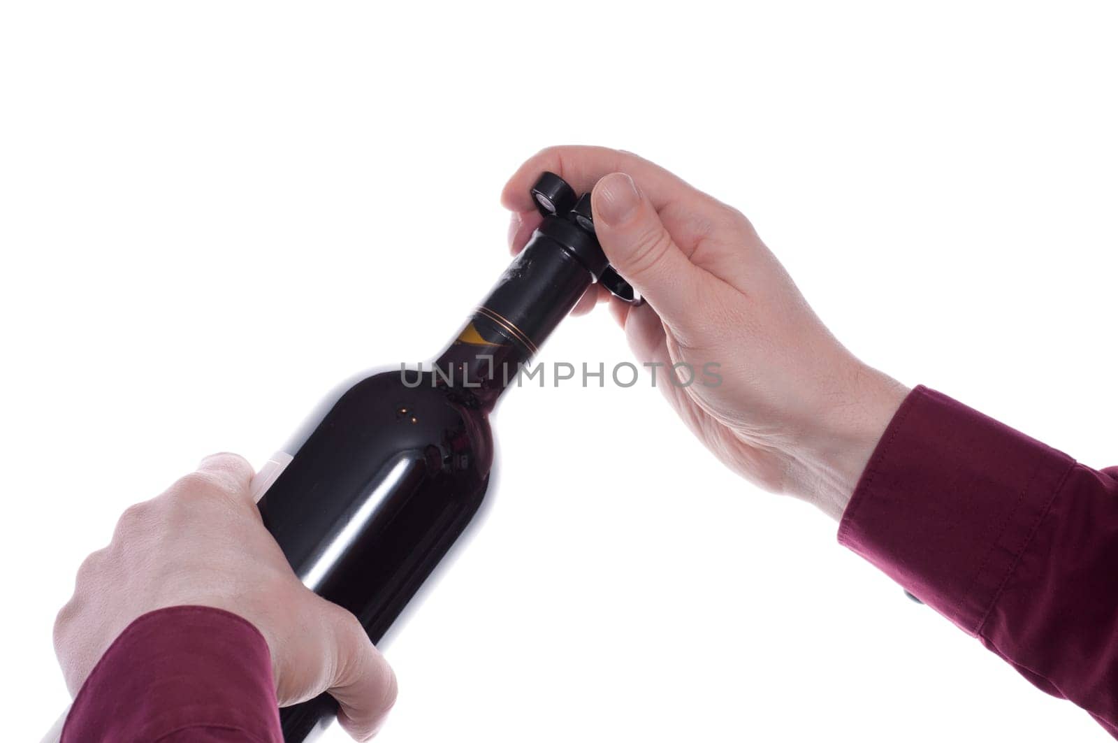 Man removing the metal capsule on a wine bottle