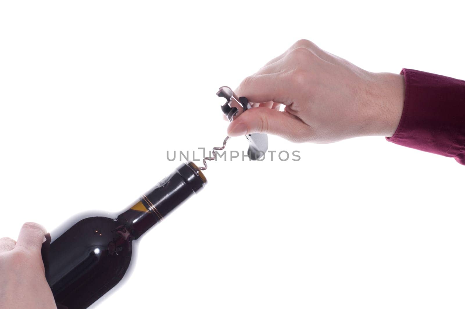A red wine bottle is opened with a corkscrew