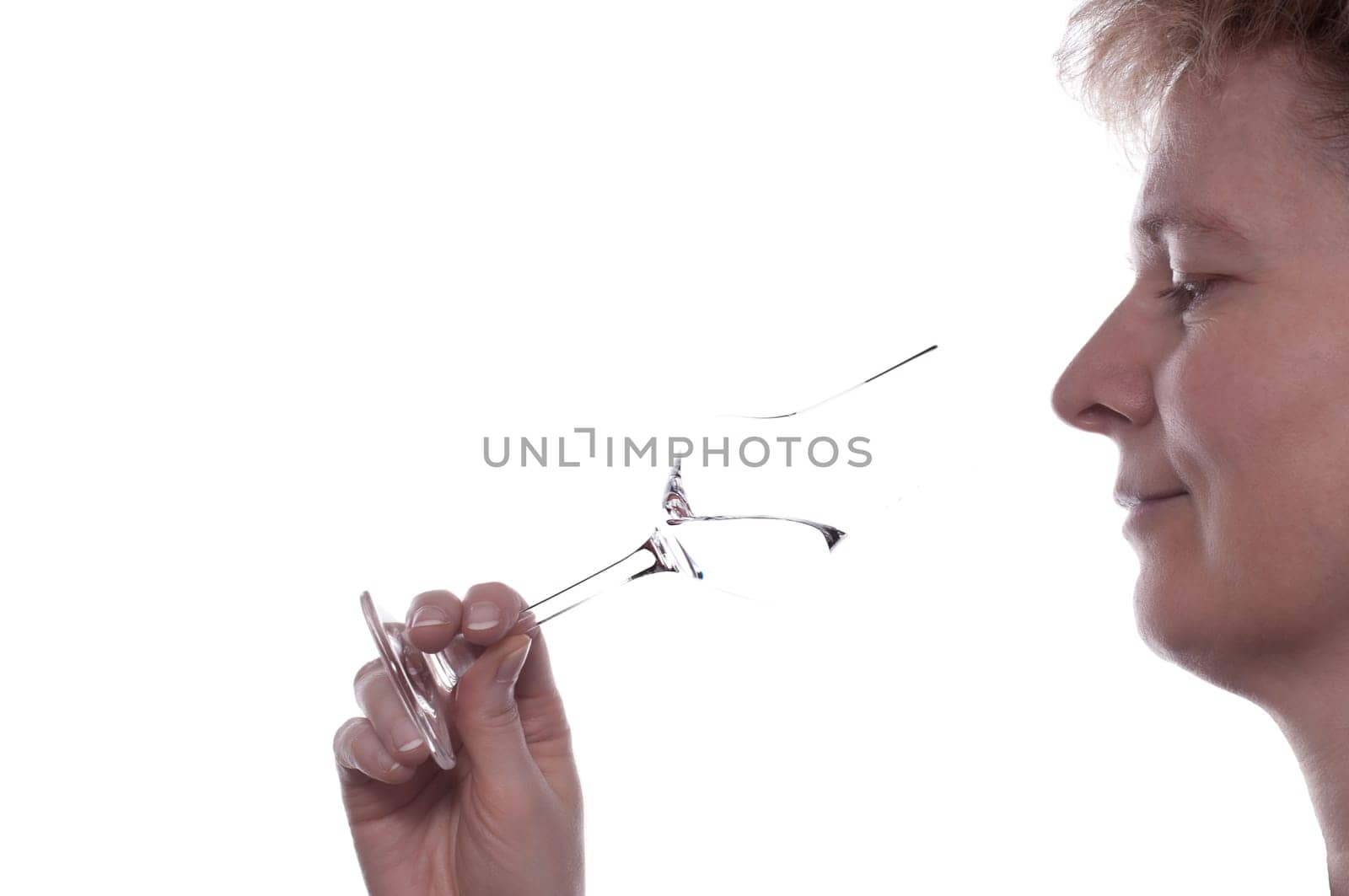A blonde woman drinks a grappa from a grappa glass