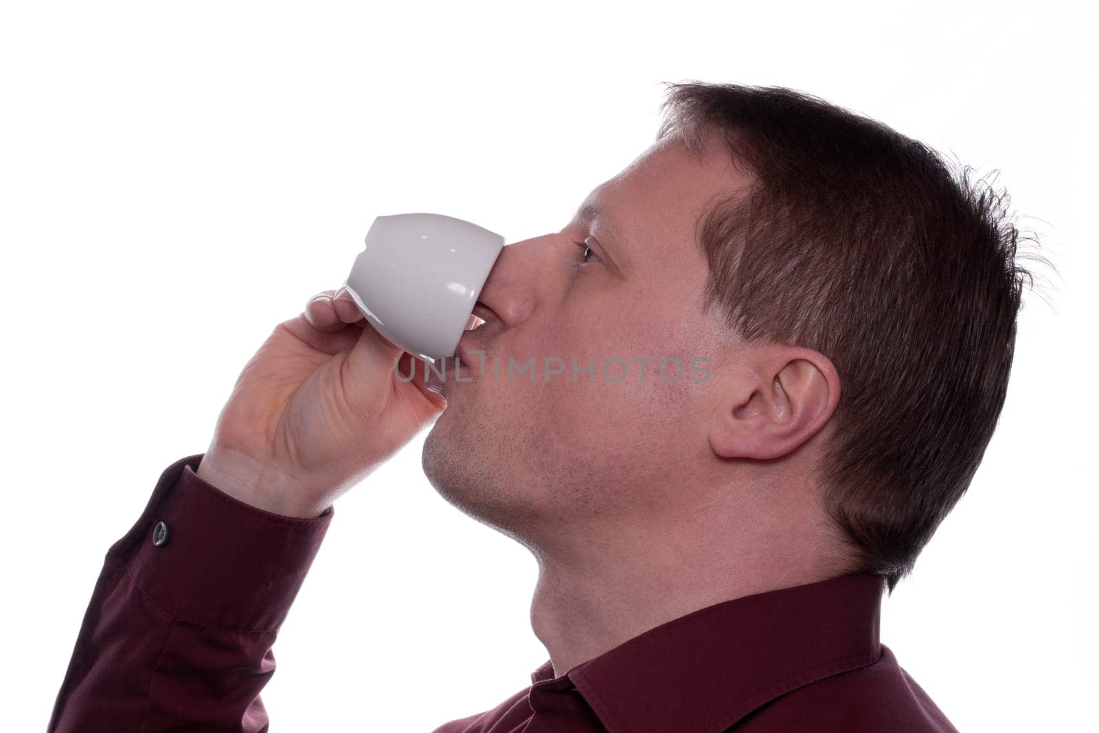 A man drinks an espresso coffee from a cup