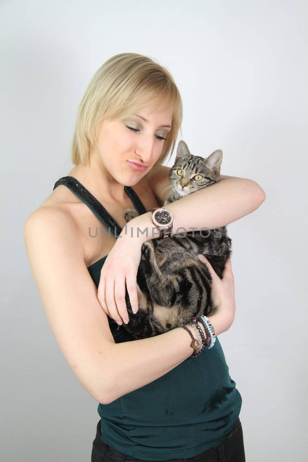 A gril holds a young cat in her hands