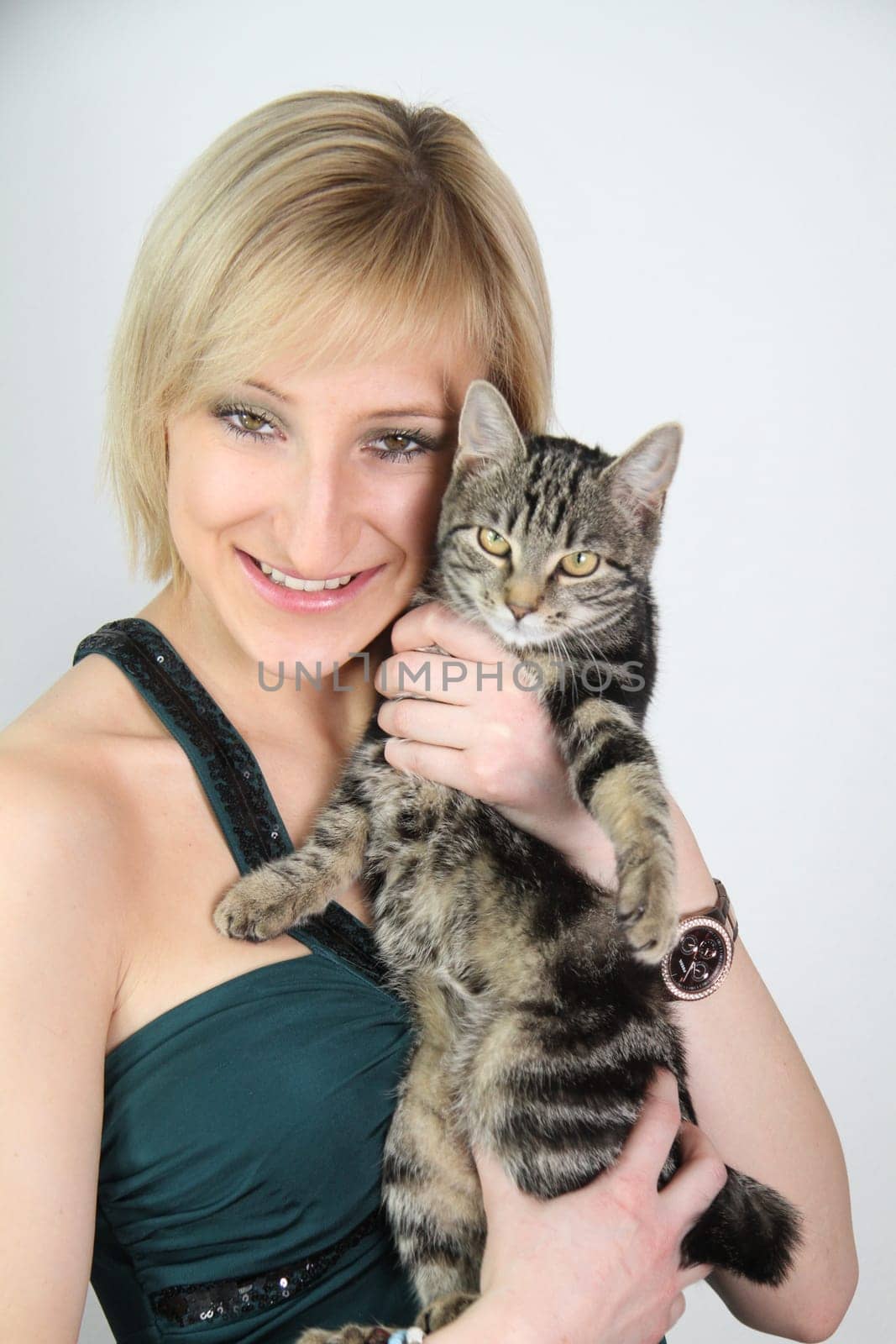A gril holds a young cat in her hands