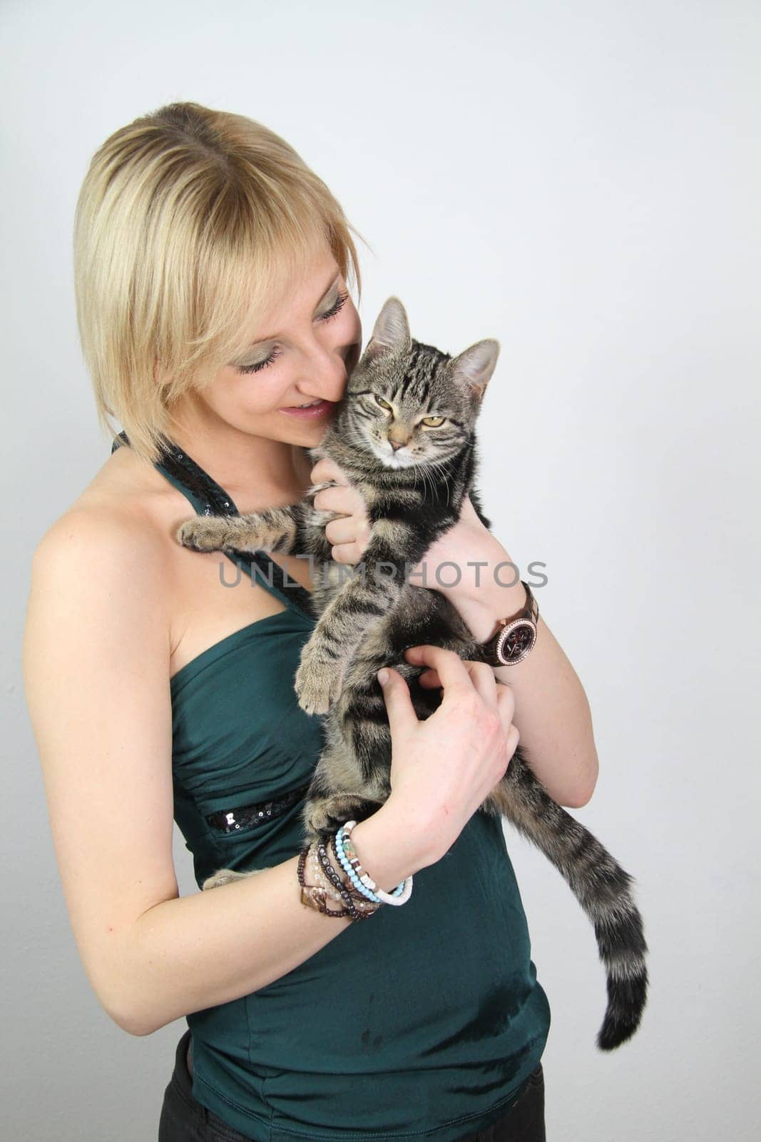 A gril holds a young cat in her hands