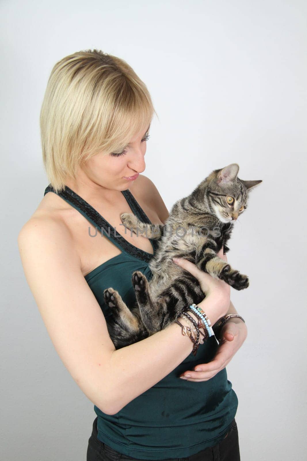 A gril holds a young cat in her hands