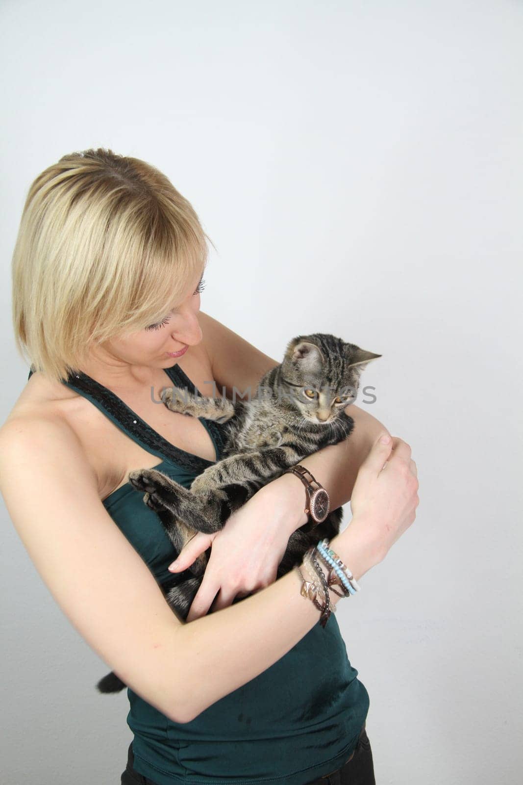 A gril holds a young cat in her hands