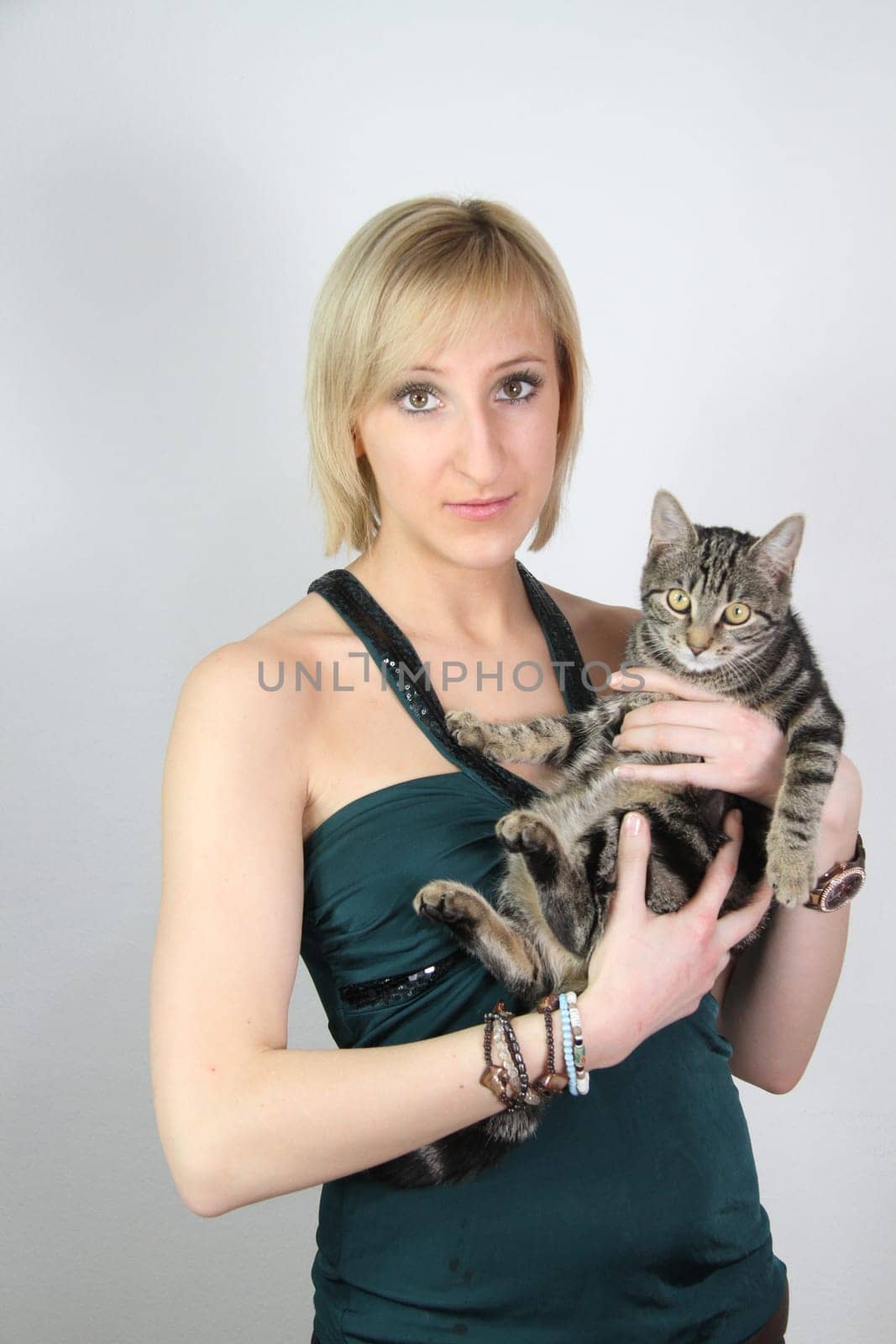 A gril holds a young cat in her hands