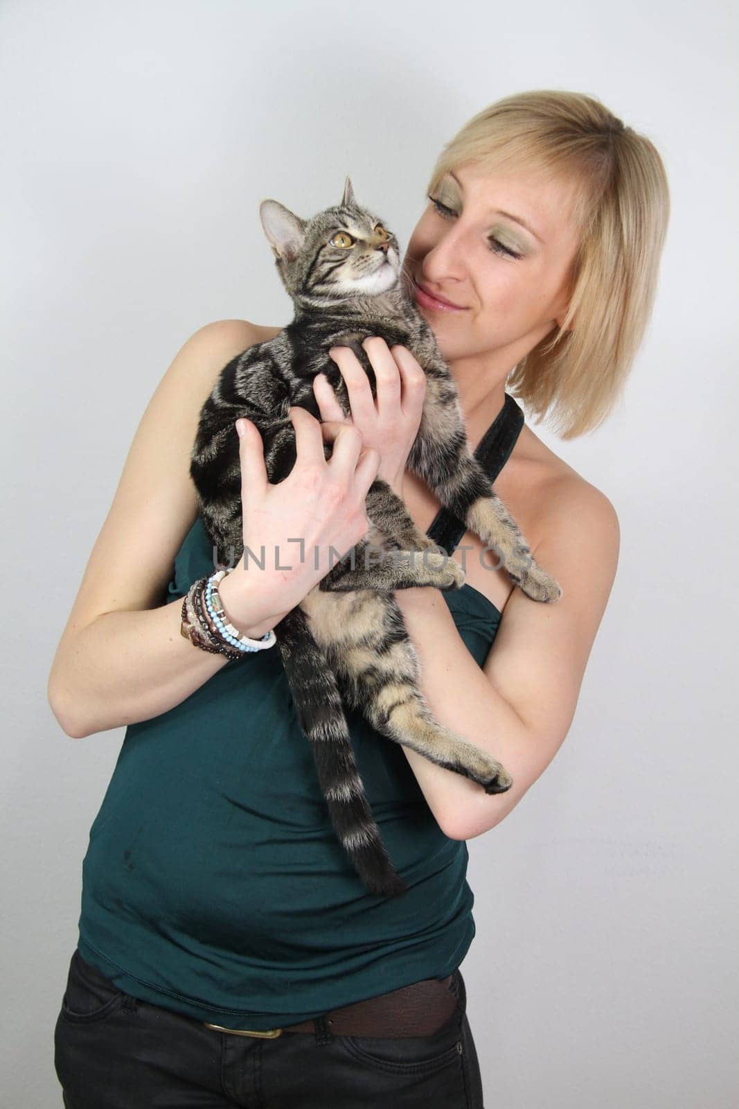 A gril holds a young cat in her hands