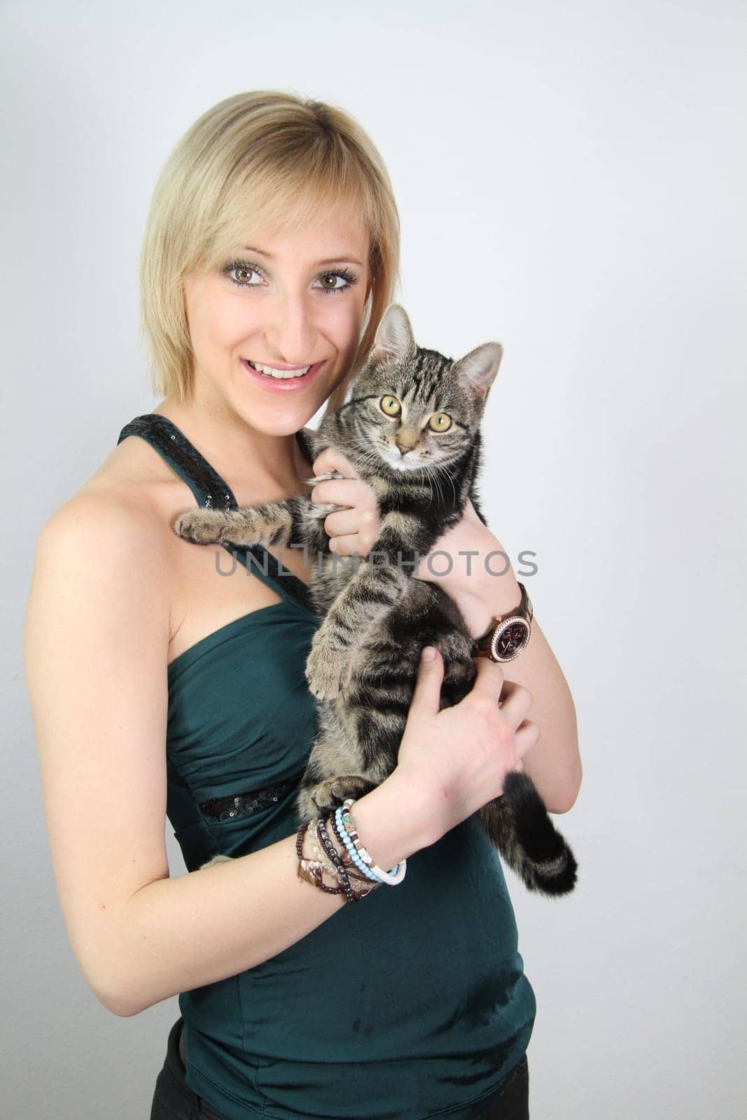 A gril holds a young cat in her hands