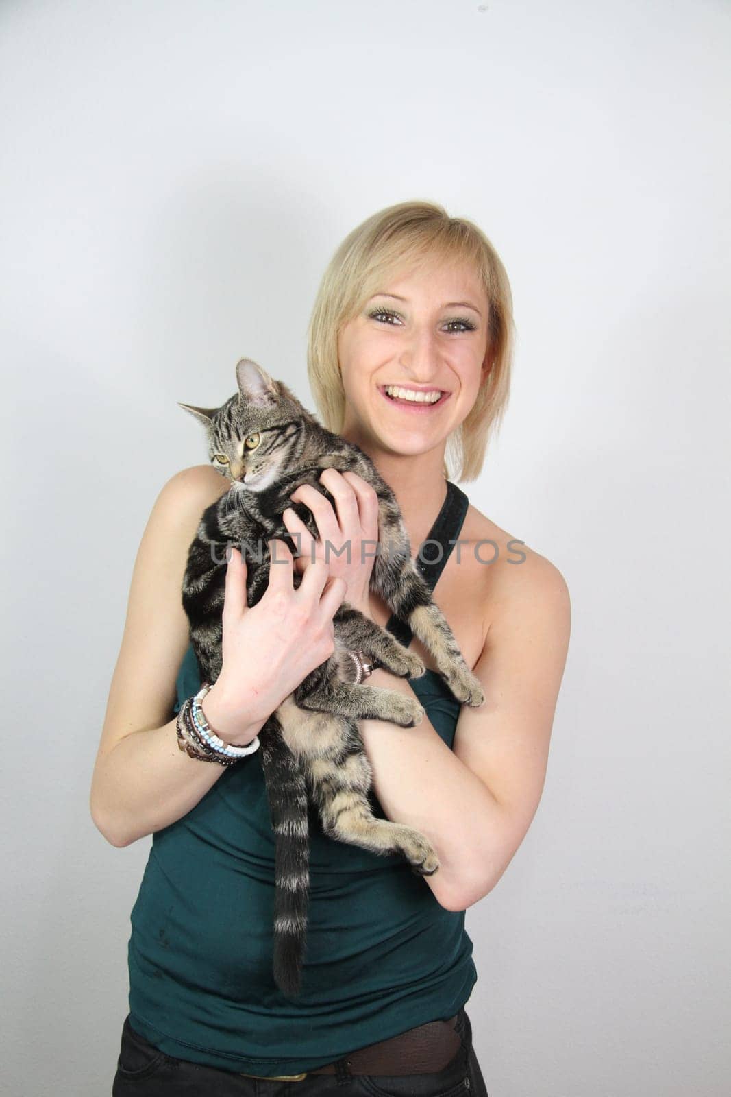 A gril holds a young cat in her hands
