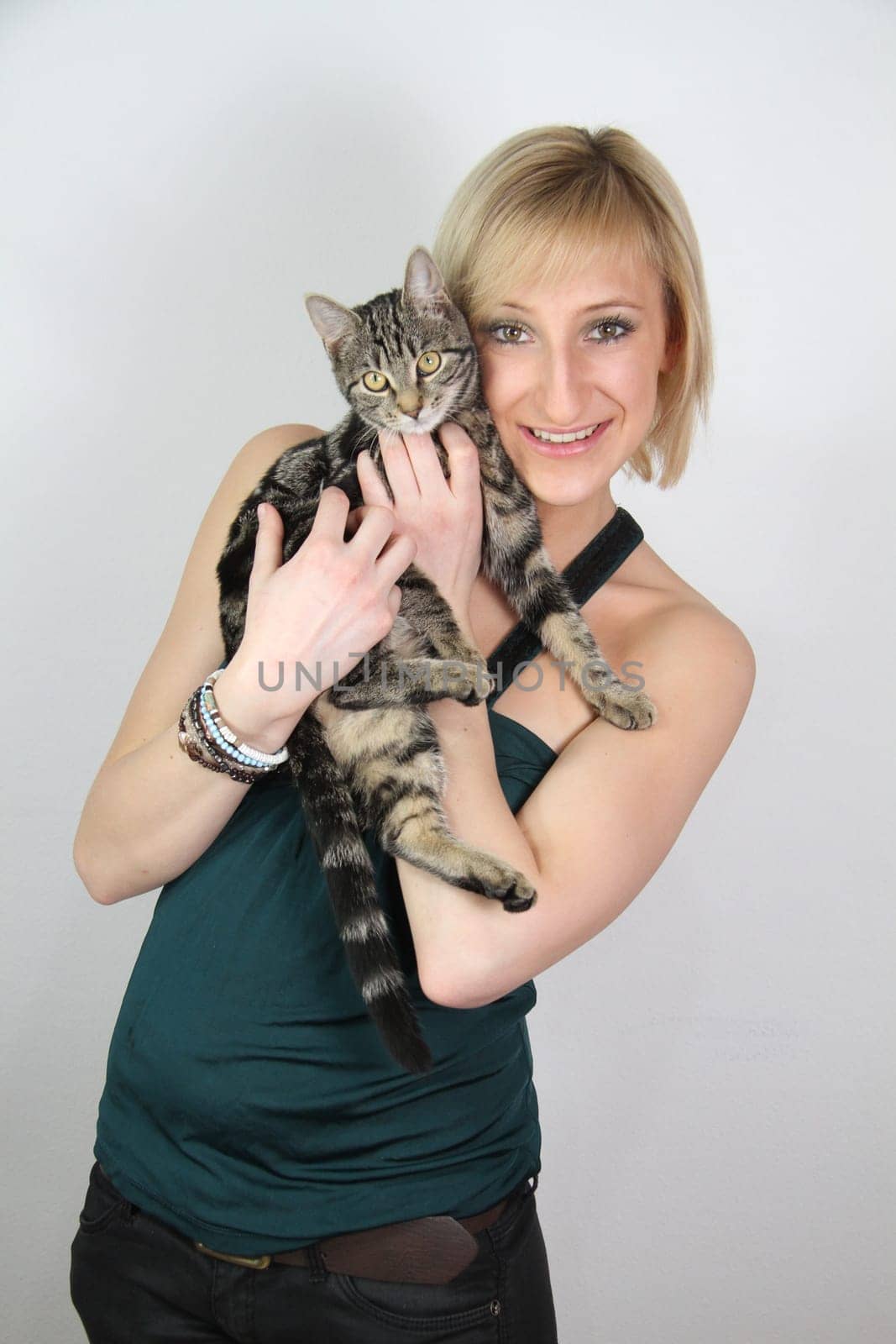 A gril holds a young cat in her hands