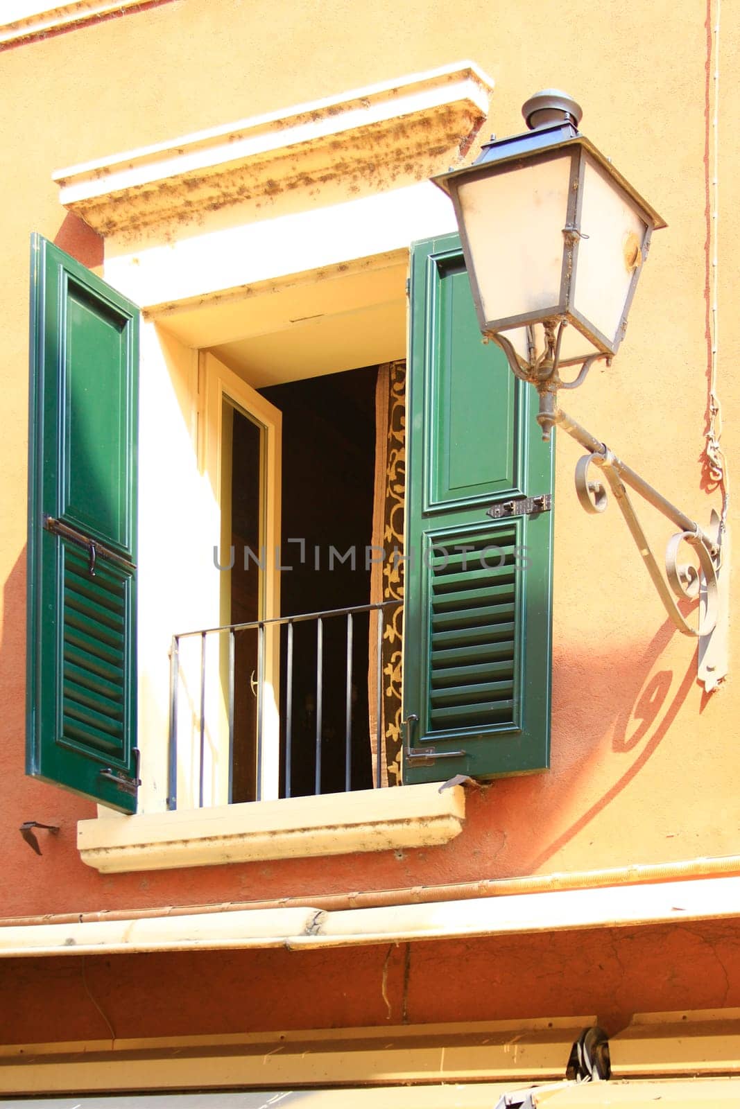 decorative window with a lantern on a house façade in Italy