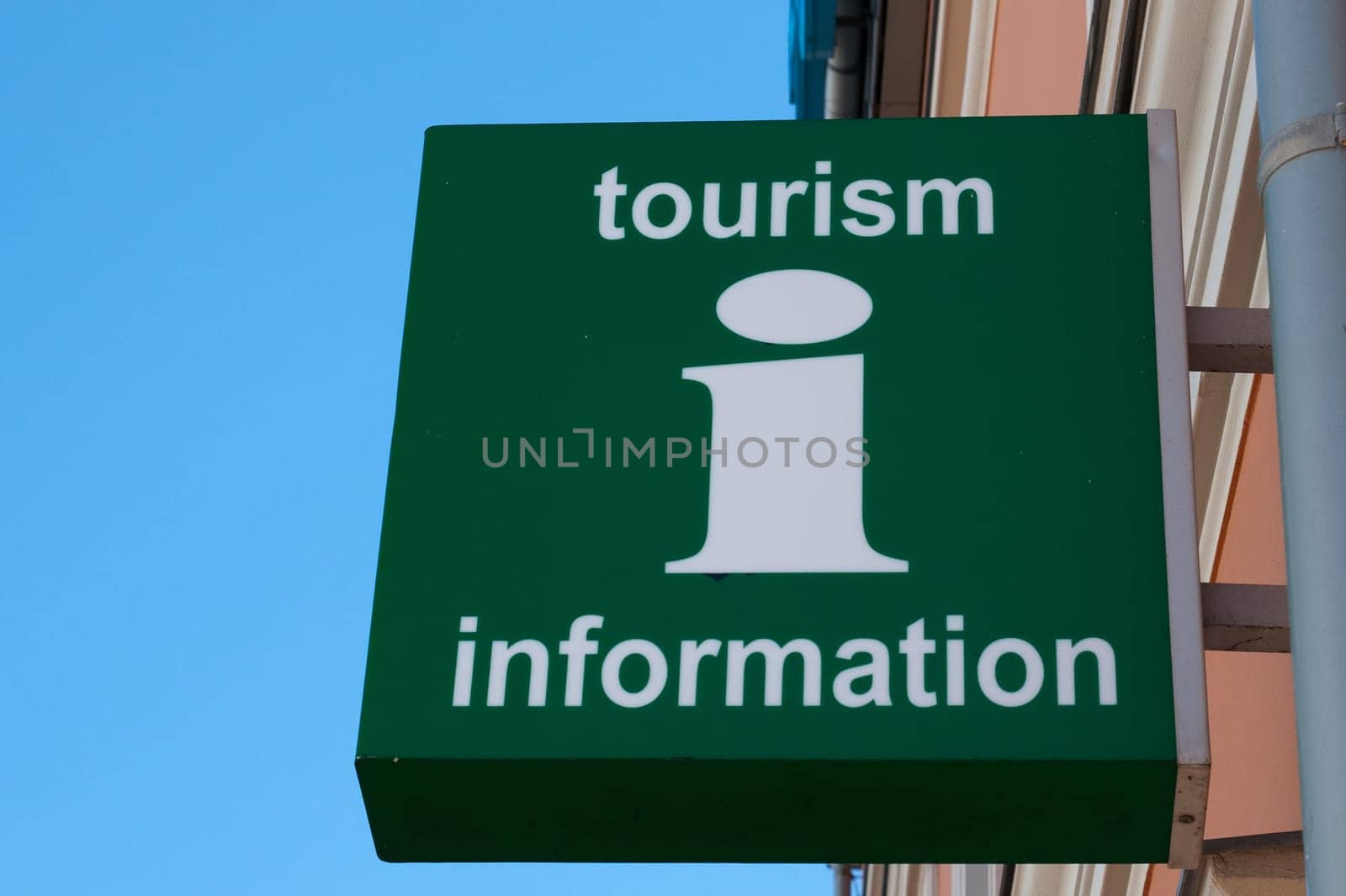 A green wall sign with Tourism