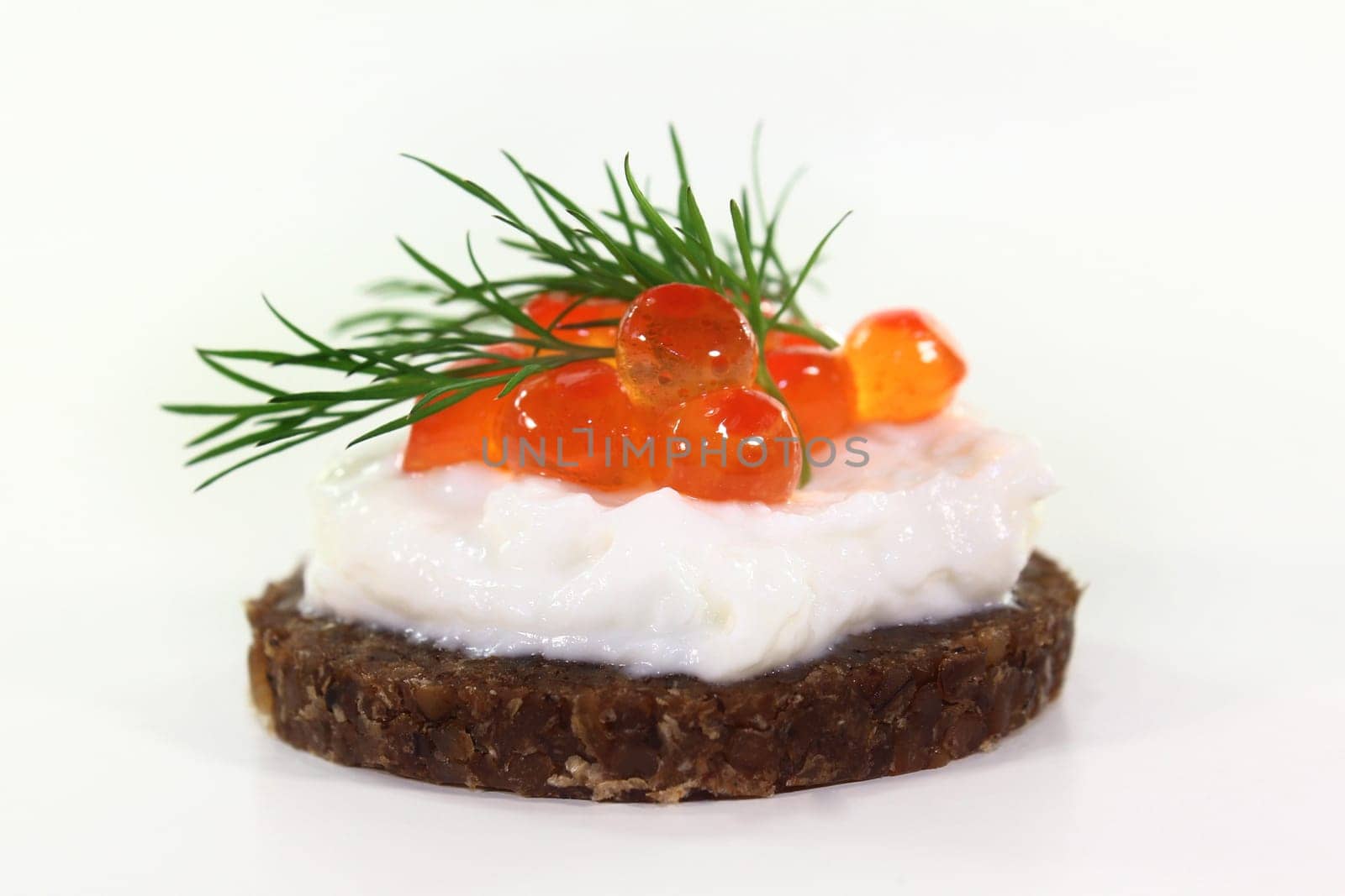Pumpernickel with caviar and dill against white background