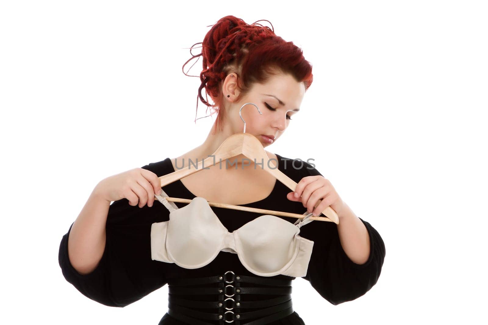 Young modern girl with red hair isolated on a white background, wearing bra.