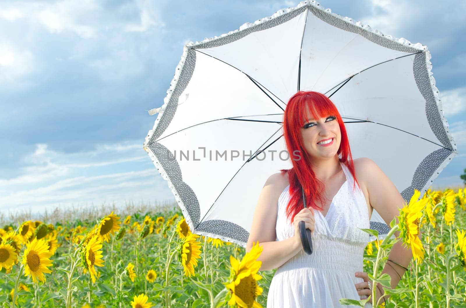 A girl holding an umbrella on a sunflower field